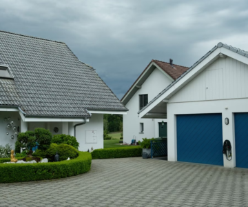 Suburban homes with blue garage doors illustrating uneven door operation concerns.